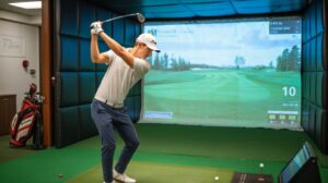 Golfer applies coaching from Golf Beginner Program in simulator swing.